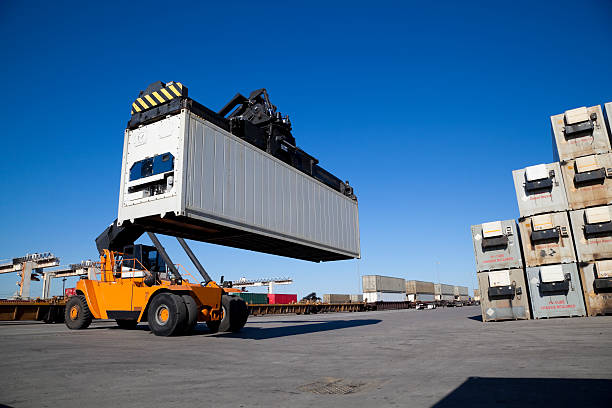 istock Crane lifting up metal storage container in railroad yard 155029606