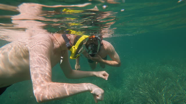Teenagers snorkeling in clean waters of Ligurian sea