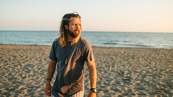 Portrait of a man with long hair and beard at the beach
