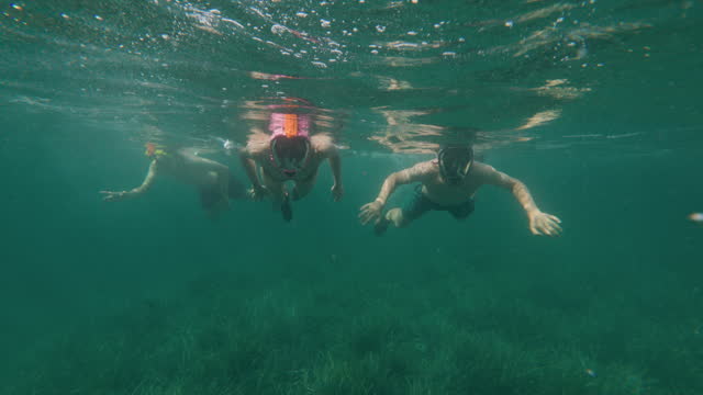 Teenagers snorkeling in clean waters of Ligurian sea