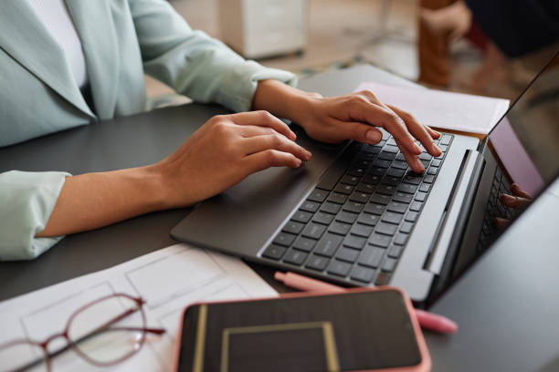 Closeup of black businesswoman using laptop and typing Closeup of elegant black businesswoman using laptop while working in successful career in office, copy space typing stock pictures, royalty-free photos & images