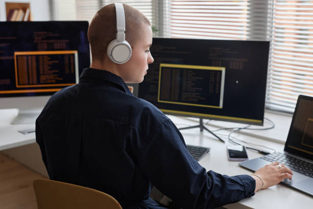 istock Bald young woman wearing headphones and using computer 1550315320