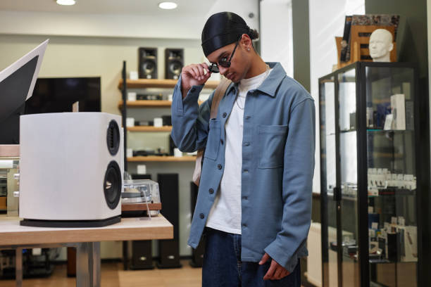 istock Side view black young man looking at speakers in music store 1550325443