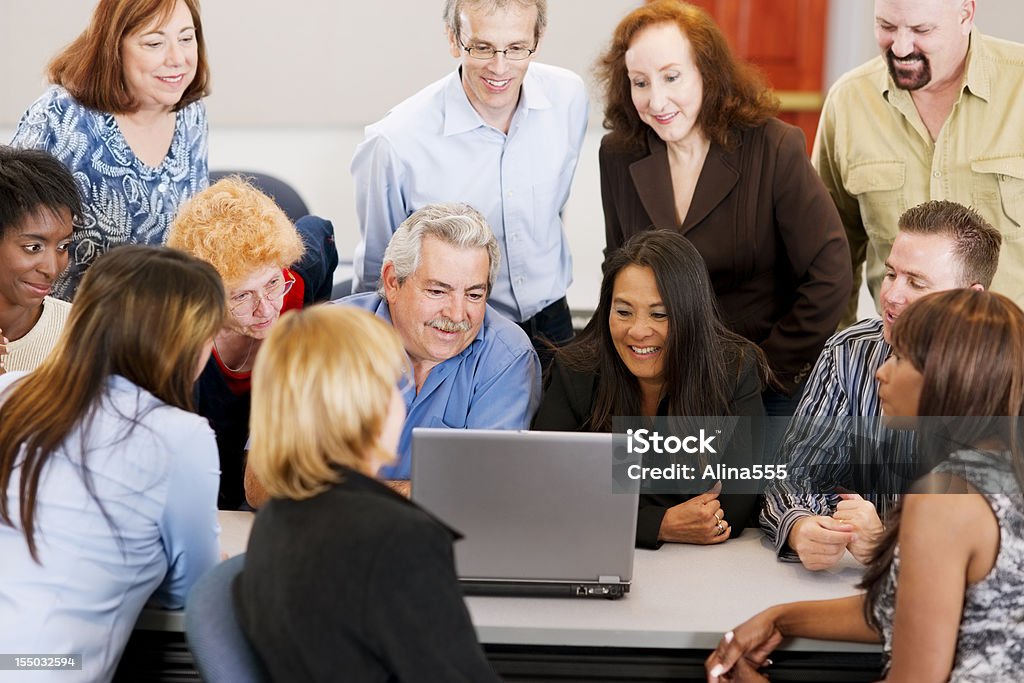 Grande grupo diversificado na frente de um laptop - Foto de stock de Audiência royalty-free