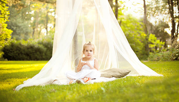 Little Girl in Canopy Under Tree stock photo