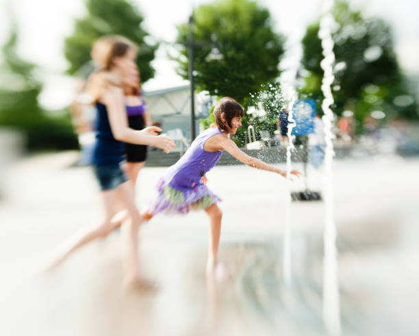 istock two girls play with fountain 155032882