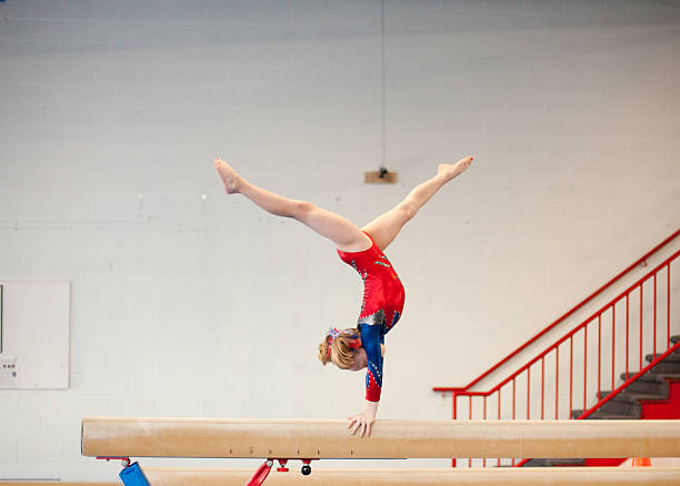 young gimnasta en hacer el pino dividido en barra de equilibrio - barra de equilibrio fotografías e imágenes de stock
