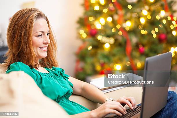 女性のリビングルームのクリスマスシーズンにノートパソコン - ノートパソコン作業のストックフォトや画像を多数ご用意 - ノートパソコン作業, 女性, 女性一人