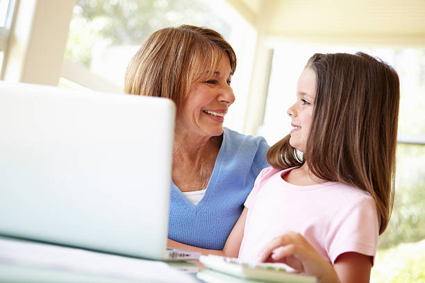 istock Hispanic Grandmother Using Laptop With Granddaugher 155034757