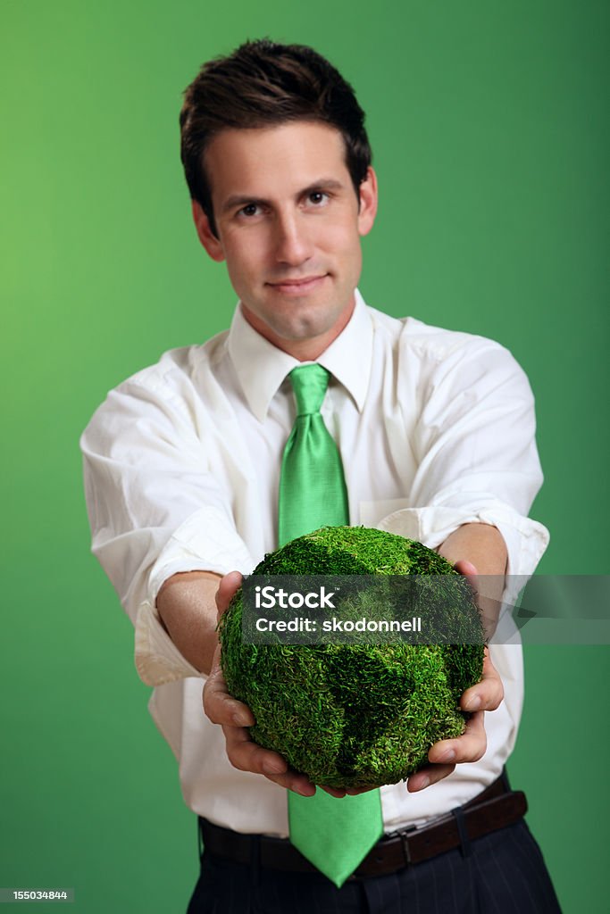 Businessman Holding a Green Earth  Globe - Navigational Equipment Stock Photo