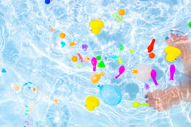 Colorful water balloons with water drops on black background.