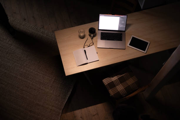 High angle view of a full office desk during late night work without people.