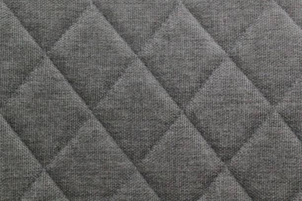 istock Close-up texture of grey stitched threads textile with seam background. Rhombus pattern for interior car, sofa, wall covering, headboard. Natural material on furniture backdrop. Classic design 1550359244