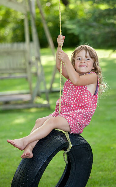 симпатичная молодая девушка на качели из шины - tire swing стоковые фото и изображения