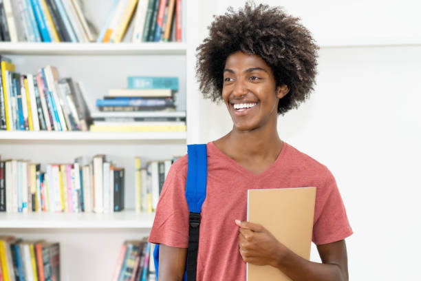 Smart african american male student with backpack and paperwork stock photo