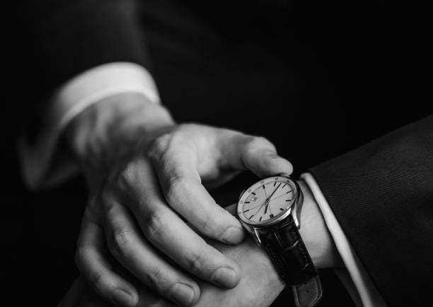 時計で時間を確認する - businessman checking the time men male ストックフォトと画像