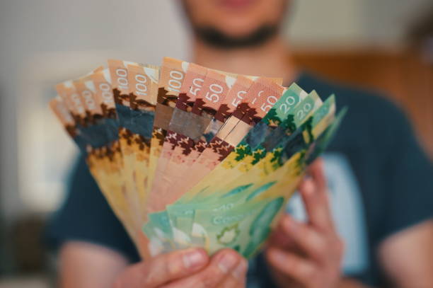 캐나다 달러 지폐를 들고 있는 남자 - canadian currency 뉴스 사진 이미지