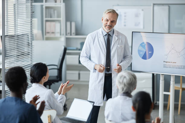 istock Happy experienced clinician in lab coat standing in front of audience 1550388115