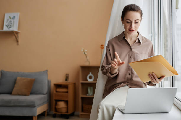 istock Young businesswoman working in home interior by window 1550405191