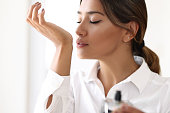 Woman testing perfume by sniffing