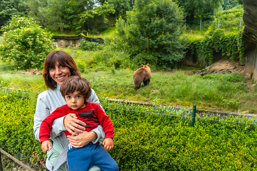 A mother with her son visiting a brown bear in a park in the municipality of Borce in the French Pyrenees