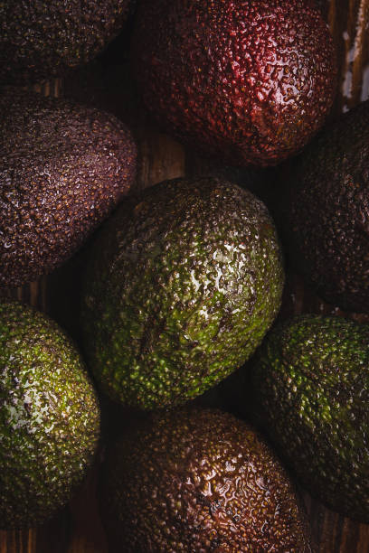 Beautiful ripe avocados on a dark wooden background.