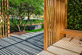 Modern wooden arbor. Modern wooden gazebo in courtyard, backyard. Urban gazebo, relaxing garden design.