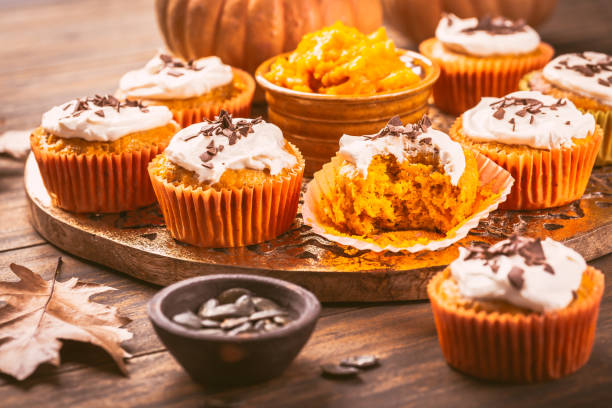 istock Spicy pumpkin muffins or cupcakes with cream cheese frosting 1550427113