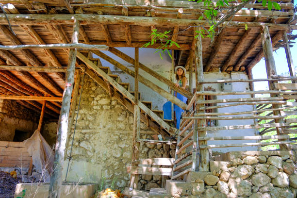 a woman climbing the stairs of an old farmhouse
