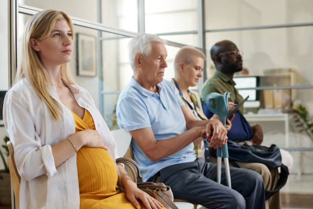 Pregnant woman sitting in a queue stock photo