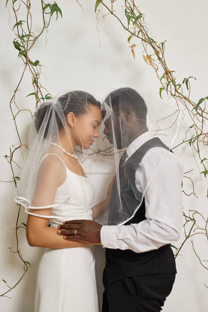 istock Elegant black couple as bride and groom embracing affectionately 1550450827
