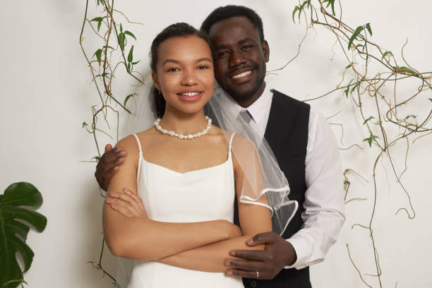 istock Young black couple as bride and groom embracing 1550450829
