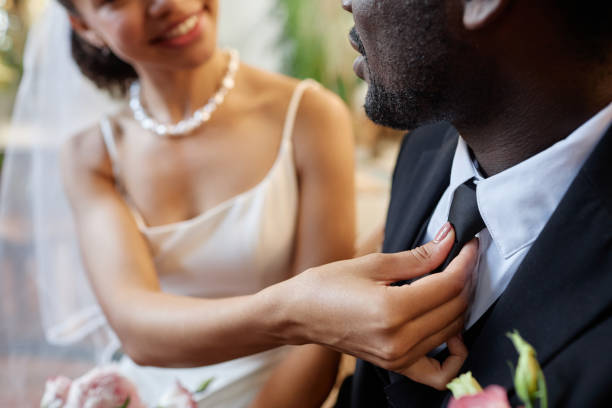 istock Black couple getting married with bride adjusting tie for groom 1550451402