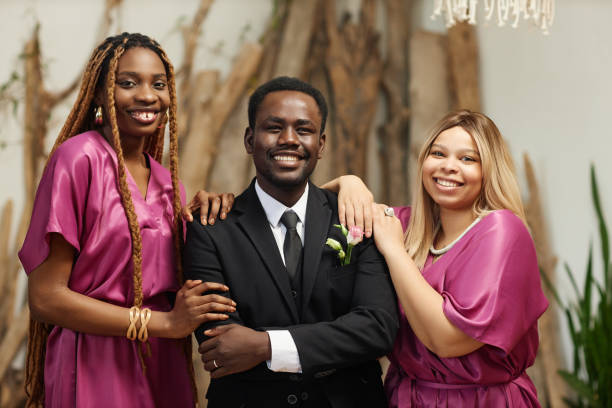 istock Young black man as groom posing with bridesmaids during wedding ceremony 1550451420