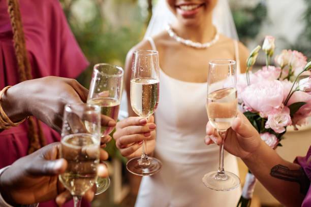 люди празднуют и произносят тосты с бокалами шампанского во время свадьбы - wedding reception wine party women стоковые фото и изображения