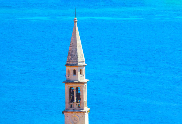 Bell tower of Budva Citadel in Montenegro . Belfry with clock tower against sea