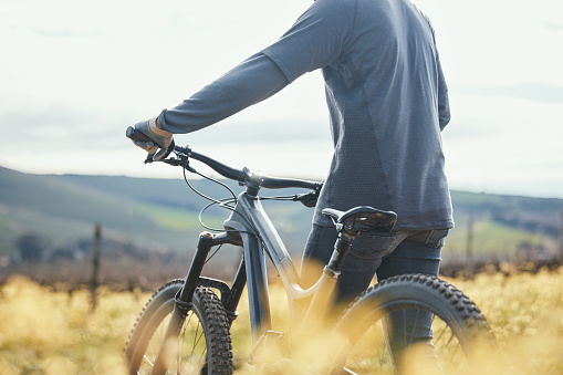 Extreme sports, cycling and man with bicycle in nature for training, workout and exercise in countryside. Fitness, cyclist and person with mountain bike for adventure, freedom and ride on dirt road