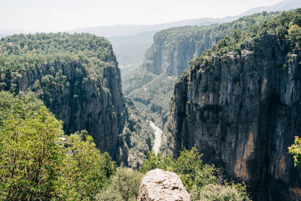 istock Scenic panoramic view on a mountain valley canyon cliffs and stone river trail. Landscape with mountain ridges, rocks covered with greenery 1550490205