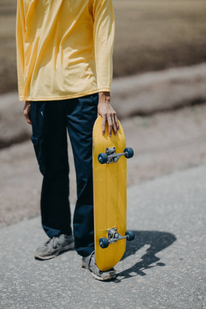 istock Unrecognizable man enjoying himself outdoors, riding his skateboard on an empty open road. 1550492879