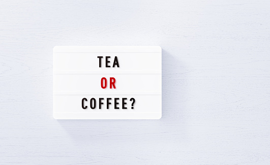 Tea or coffee written white lightbox on white wood background. Horizontal composition with copy space.