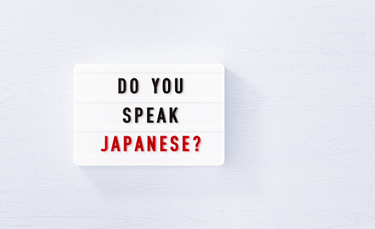 Do you speak Japanese written white lightbox on white wood background. Horizontal composition with copy space.