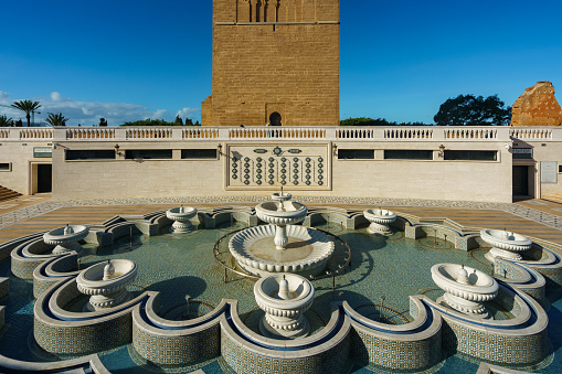 Morocco. Rabat. The magnificent Hassan Tower and the fountain on the Yacoub al-Mansour esplanade. The tower is the incomplete red sandstone minaret of a mosque began in 1195.