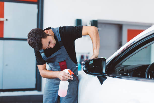 istock Car mechanic working to remove dent in workshop. 1550531805