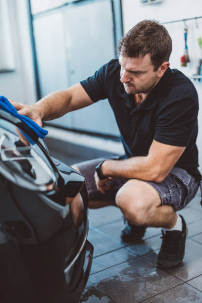 istock Service man washing car before detailing in workshop. 1550532388
