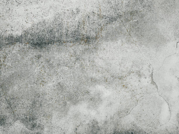 istock Grey cracked cement wall with damages and scratches. An old concrete wall background with beautiful texture. 1550533428