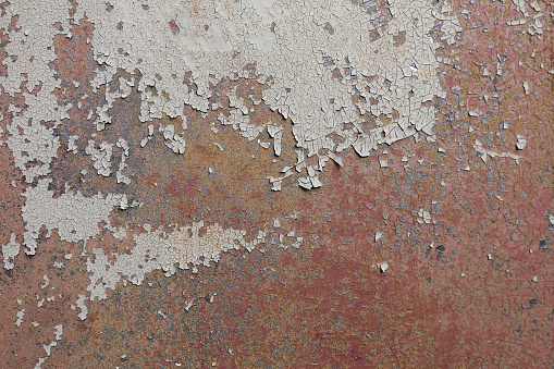 Weathered metal surface with damages and rust. An old red wall background. Abstract detailed texture. Easily add depth to your designs.