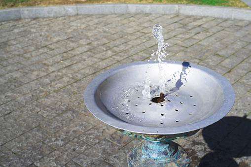 A small pond with a fountain on a beautiful fall day.