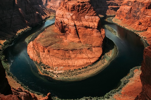 This image features a breathtaking canyon with vivid red rocks surrounding stunningly blue waters