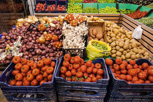5th July 2023 - Turkey, Kuşadası. Baskets with different vegetables in a market: garlic, potatoes, vegetables, peas, onion.