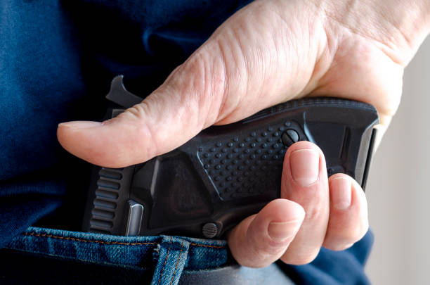 istock A person is hiding a handgun under the denim belt. 1550644297